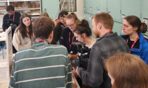 A group of people gathered round a desk looking at samples