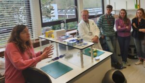 Laboratory setting. Two experts talking to a group of young people