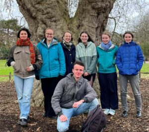 A group of young people in front of a large tree